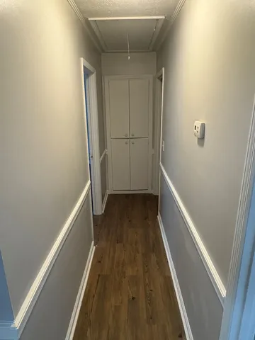 a view of a hallway with wooden floor and staircase