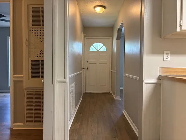 a view of hallway with stairs and wooden floor