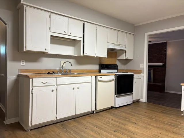 a kitchen with granite countertop white cabinets and white appliances