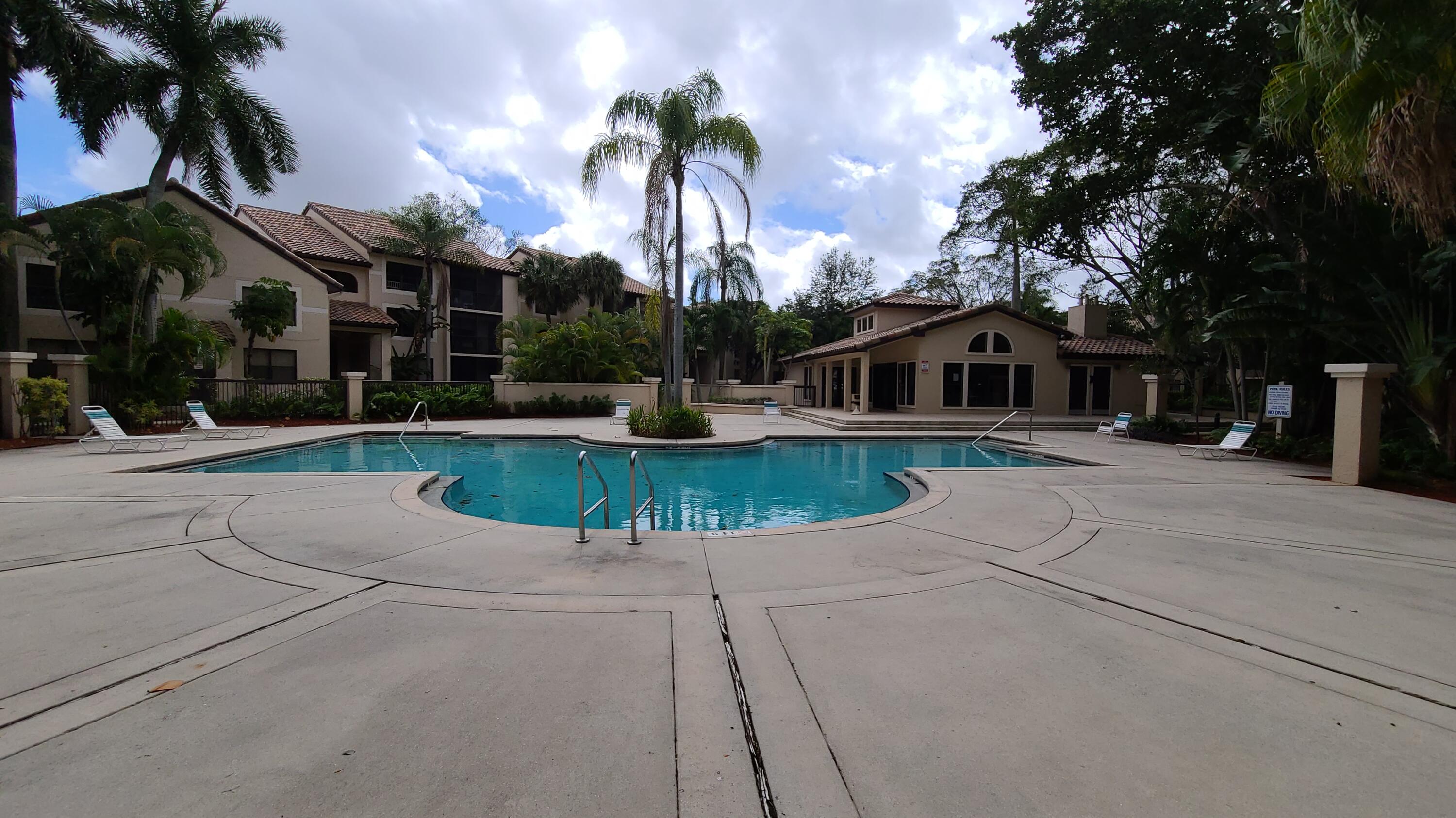 4501 West McNab Road, Unit 11 Pompano Beach, FL 33069 - Photo 11 of 32 front view of a house with a yard and palm trees