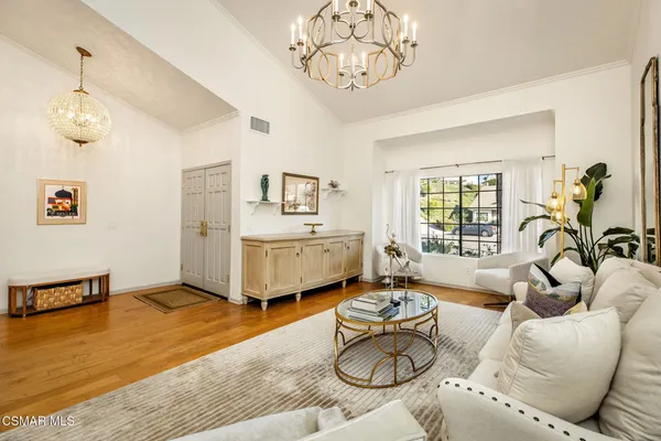 a living room with furniture chandelier and a window