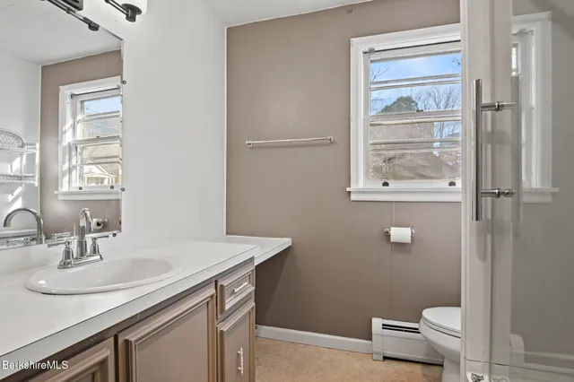 a bathroom with a sink a toilet and a mirror