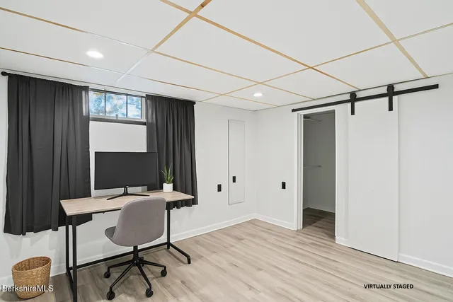 a view of a workspace with furniture and a window