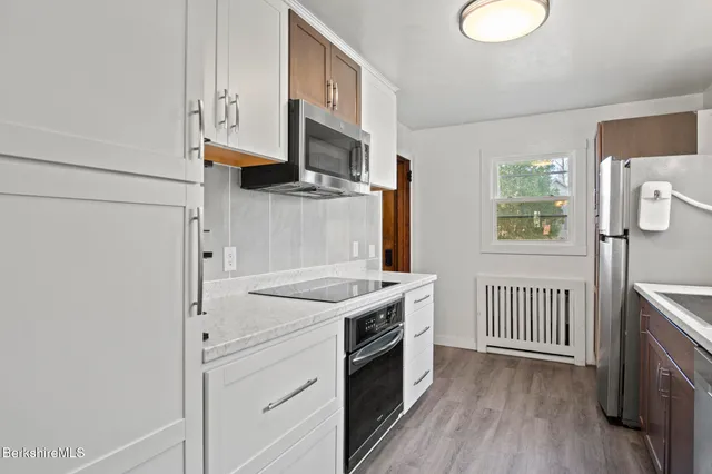 a kitchen with stainless steel appliances granite countertop a stove a sink and a refrigerator