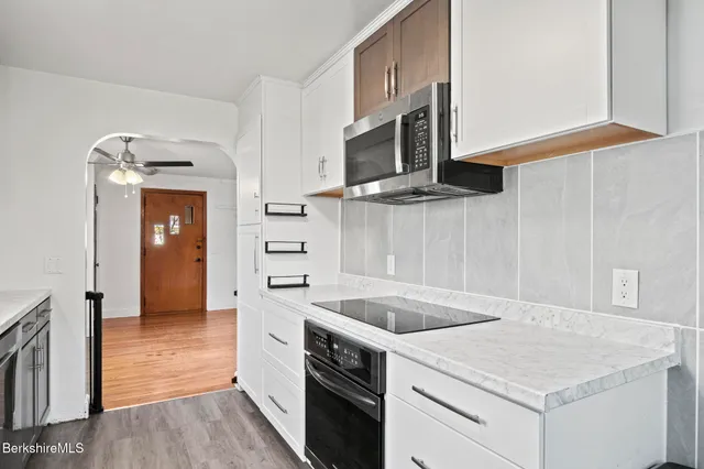 a kitchen with granite countertop cabinets stainless steel appliances and wooden floor
