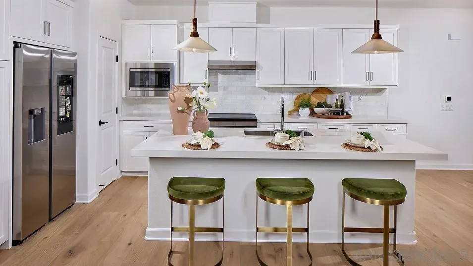 111 Metz Way Oceanside, CA 92057 - Photo 2 of 16 a kitchen with stainless steel appliances a dining table chairs refrigerator and cabinets