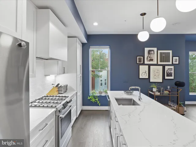 a kitchen with a refrigerator a sink dishwasher a stove and a refrigerator with wooden floor