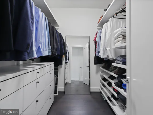 a view of walk in closet with clothes and shoes