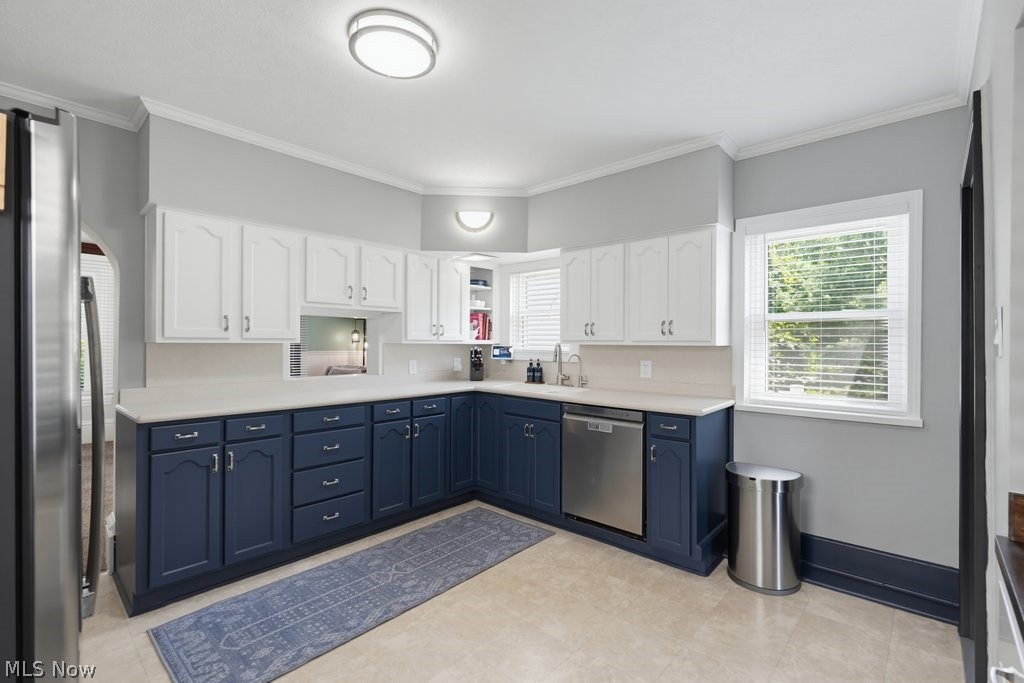 23055 Snell Road Columbia Station, OH 44028 - Photo 12 of 50 Kitchen featuring two-tone cabinetry with white upper and blue lower cabinets, light countertops, and a stainless steel dishwasher