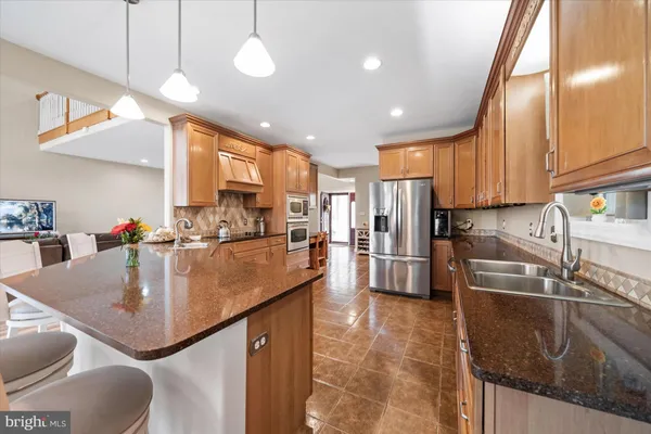 a kitchen with stainless steel appliances granite countertop a sink a stove and a refrigerator