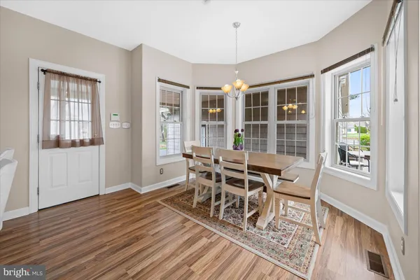 a dining room with wooden floor and large window
