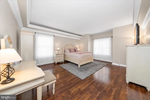 a spacious bedroom with a bed and wooden floor