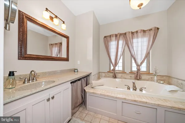 a bathroom with a granite countertop sink and a window