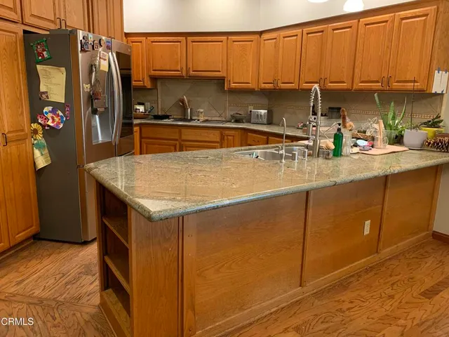 a kitchen with a sink a stove cabinets and a wooden floor