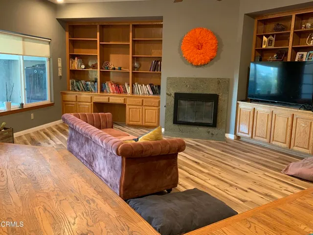 a living room with furniture a flat screen tv and a fireplace
