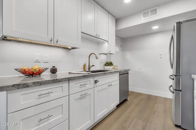 a kitchen with stainless steel appliances granite countertop a refrigerator stove and sink
