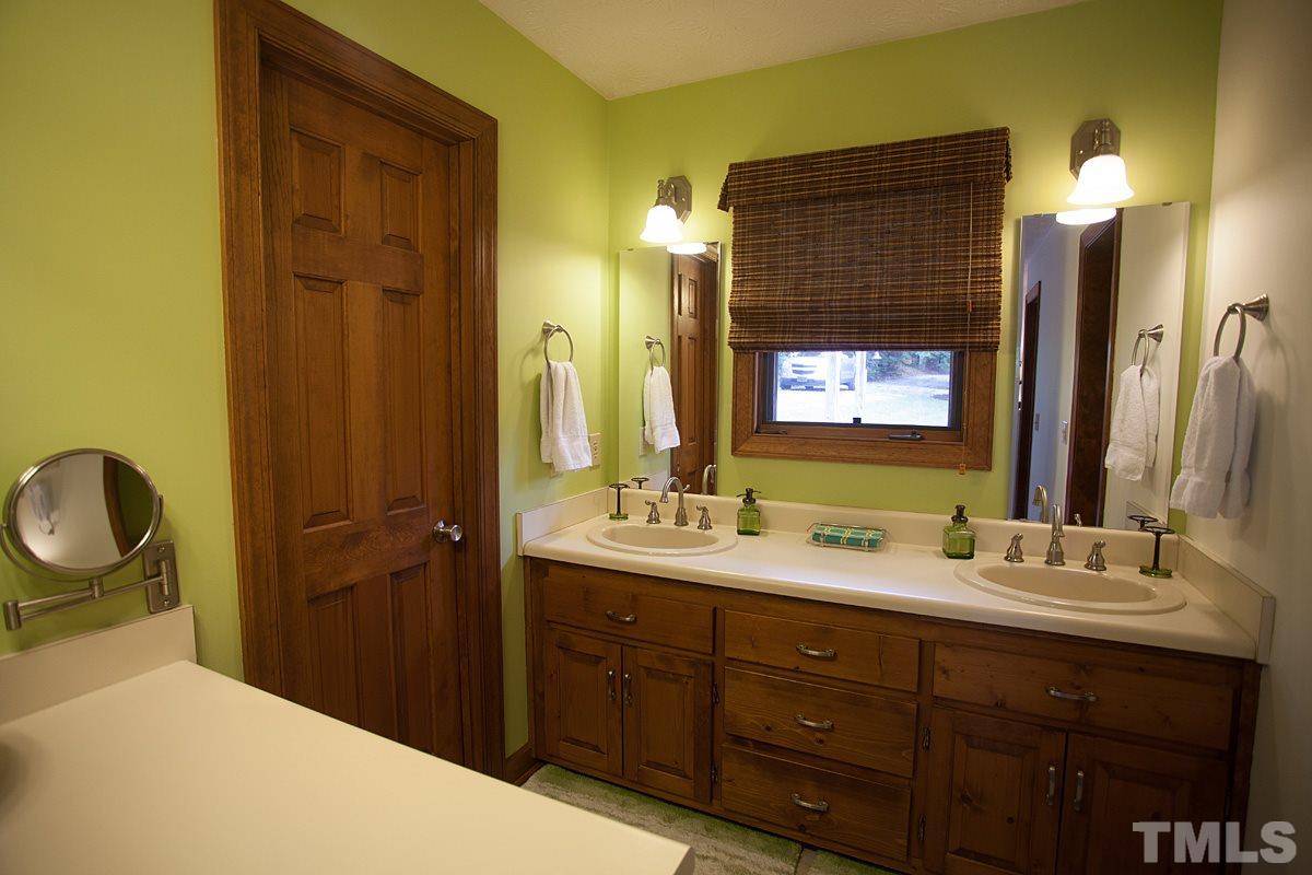 11 Hidden Hills Road Roxboro, NC 27574 - Photo 14 of 25 a bathroom with a double vanity sink and a mirror