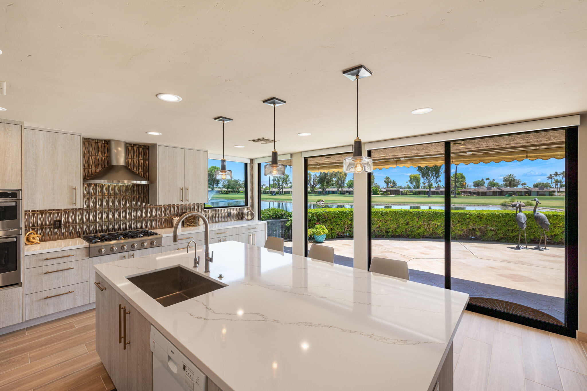 4 Barnard Court Rancho Mirage, CA 92270 - Photo 24 of 62 a kitchen with a stove a sink and a wooden floor