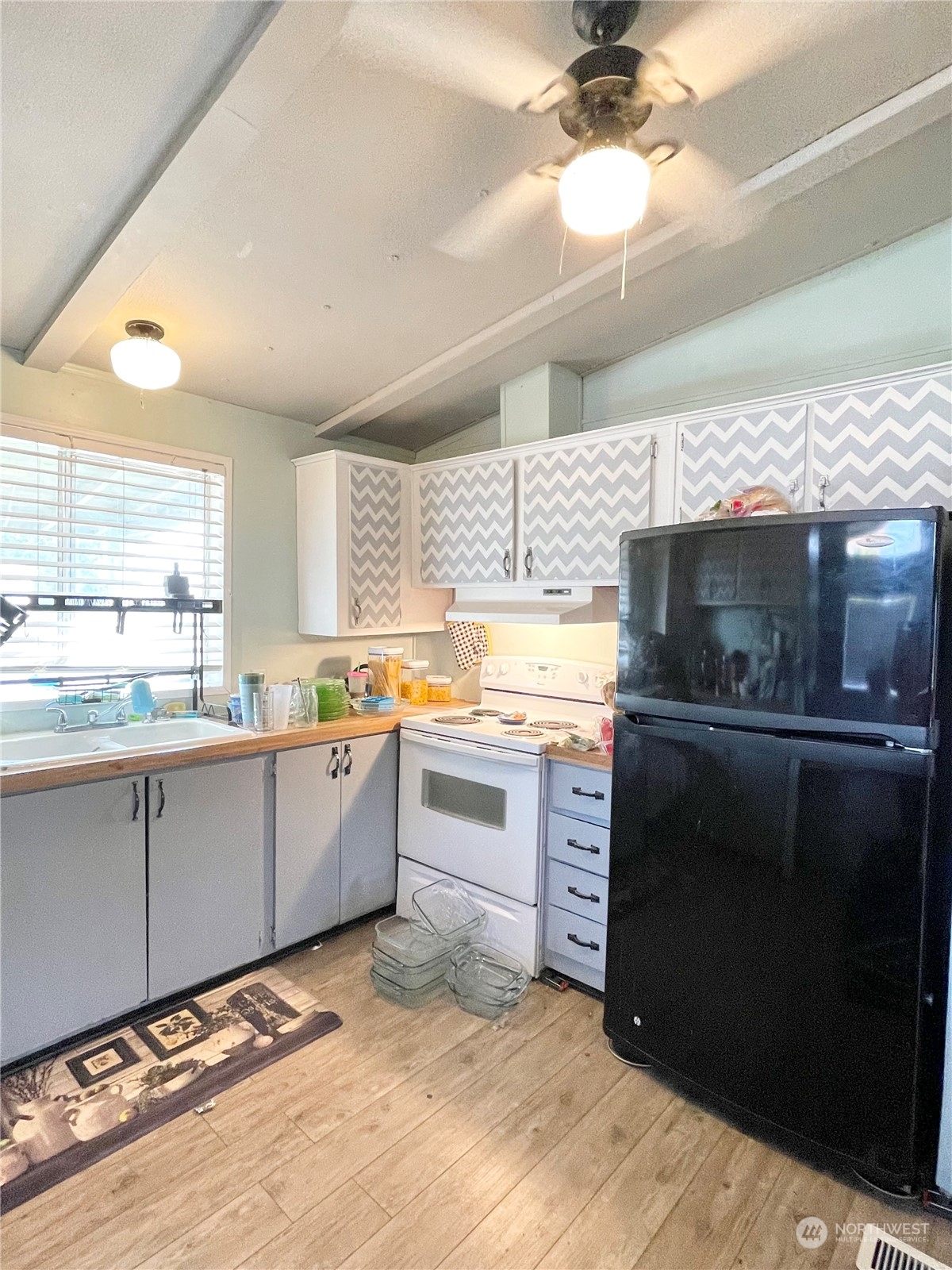52 Engh Road, Unit 26 Omak, WA 98841 - Photo 11 of 29 a kitchen with stainless steel appliances kitchen island granite countertop a stove a sink and a microwave