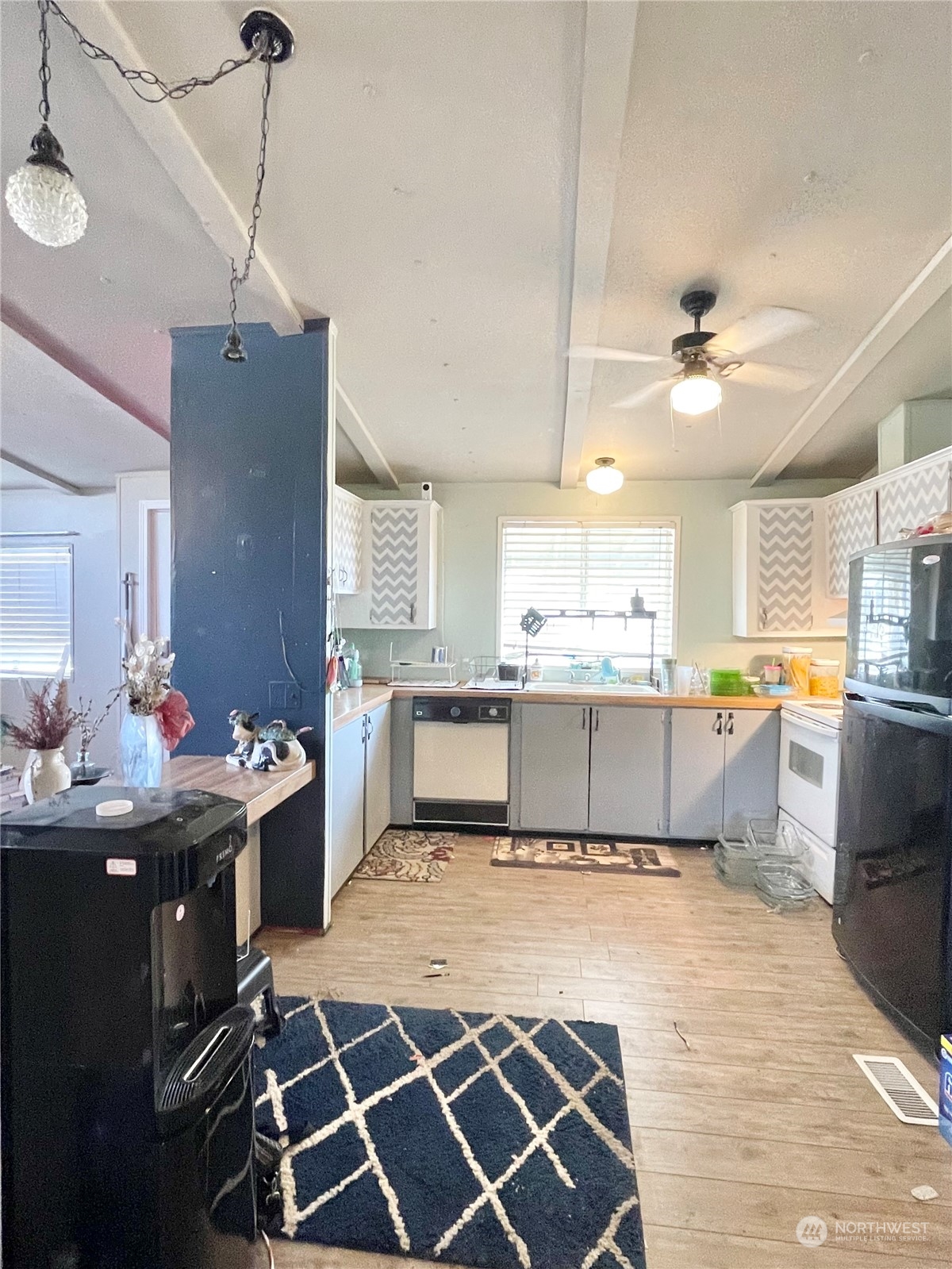 52 Engh Road, Unit 26 Omak, WA 98841 - Photo 12 of 29 a kitchen with a stove a sink dishwasher and a refrigerator with wooden floor