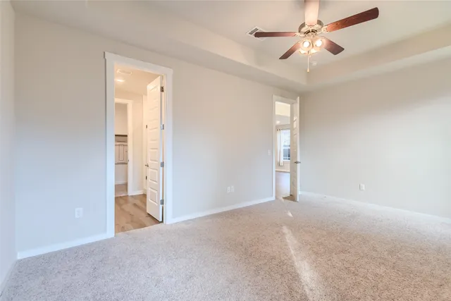 an empty room with closet and a ceiling fan