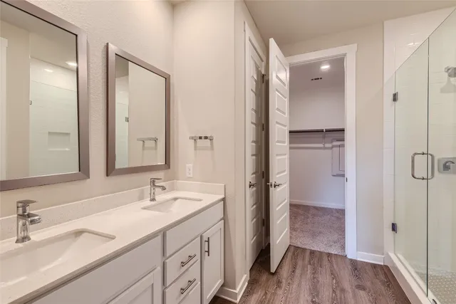a bathroom with a double vanity sink mirror and shower