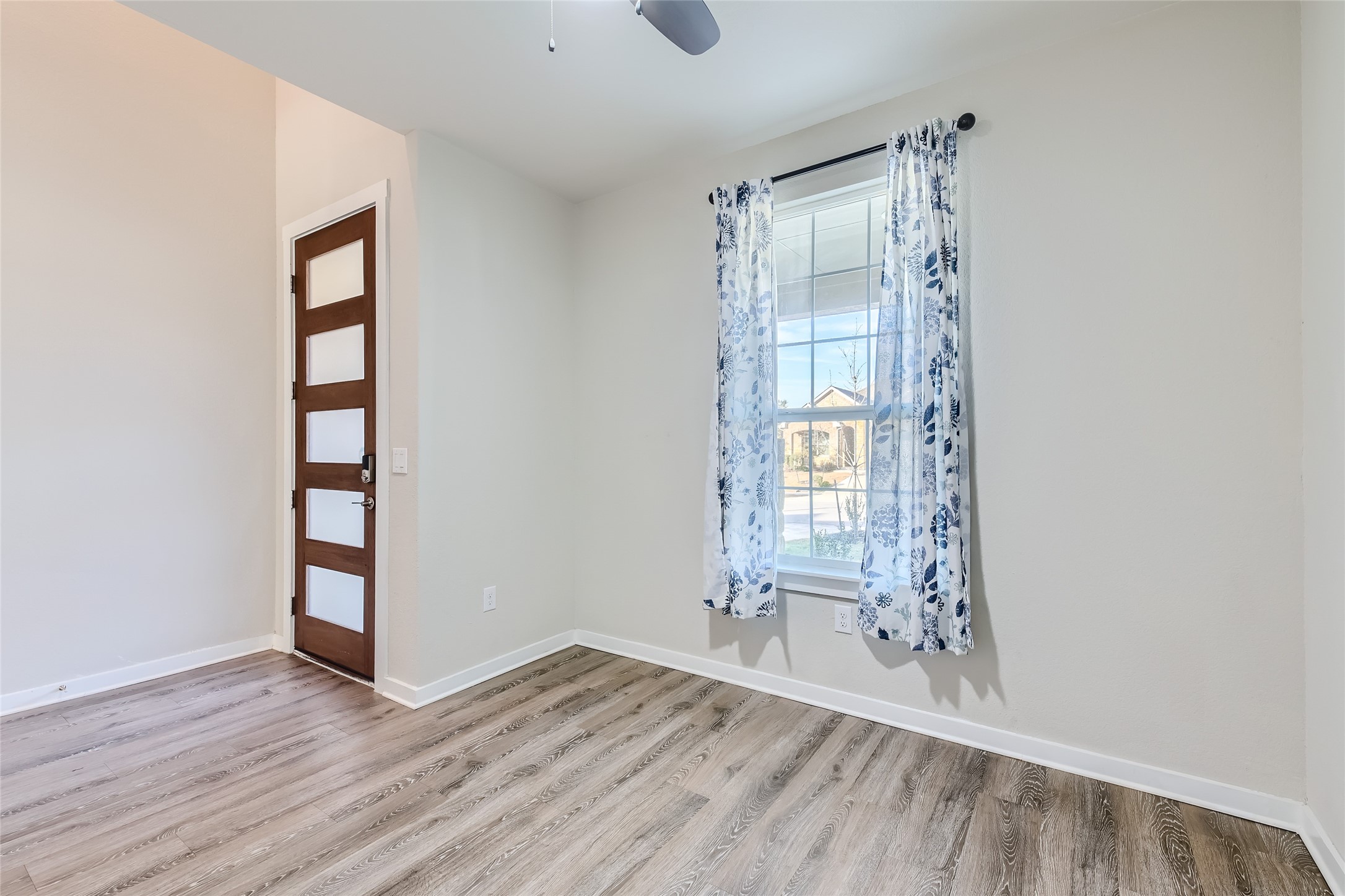 2212 Alamar Walk Leander, TX 78641 - Photo 6 of 29 an empty room with wooden floor and windows