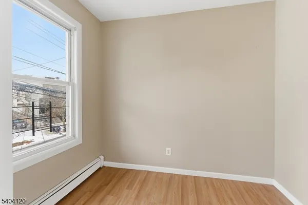 a view of a room that has wooden floor and windows in it