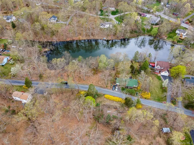 a view of a lake with a yard and large trees