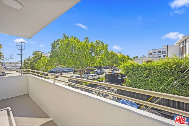 a view of a balcony with an outdoor seating and trees