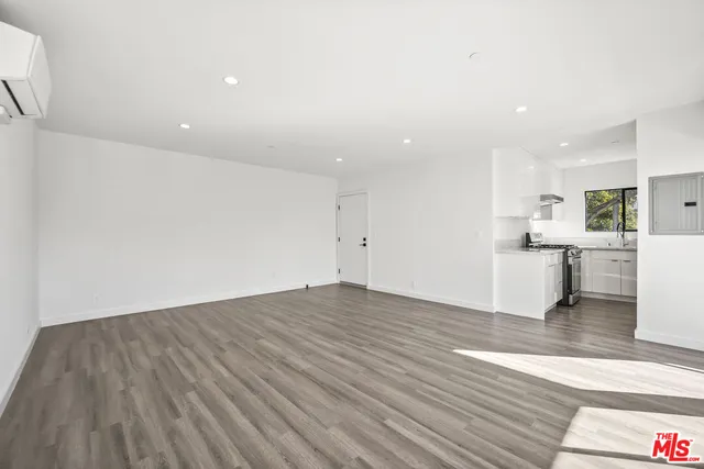 a view of a kitchen with wooden floor and electronic appliances