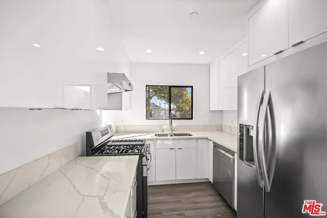 a kitchen with a sink stainless steel appliances and window