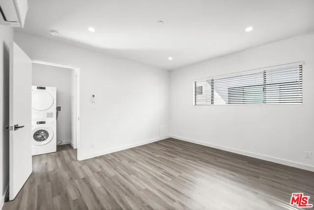 a view of a big room with wooden floor and windows