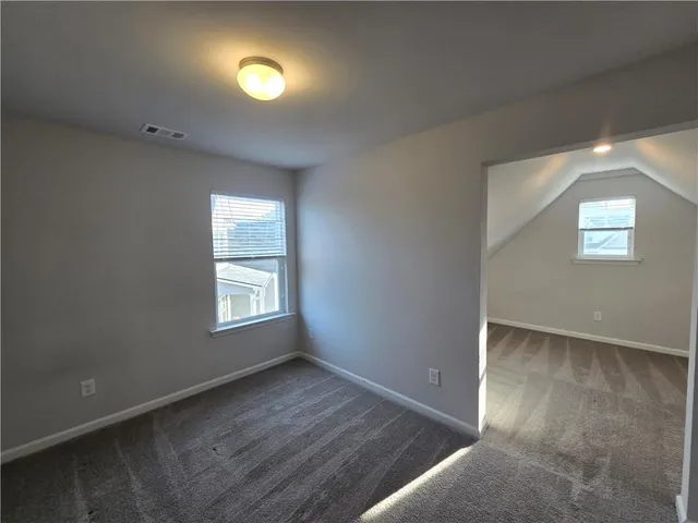 an empty room with windows and closet