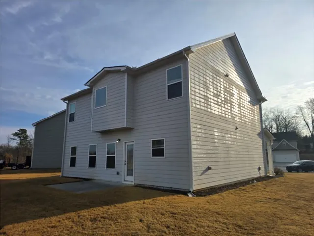 a view of a house with backyard and a tree