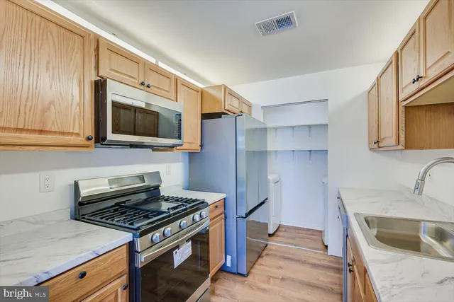 a kitchen with stainless steel appliances granite countertop a sink stove and cabinets