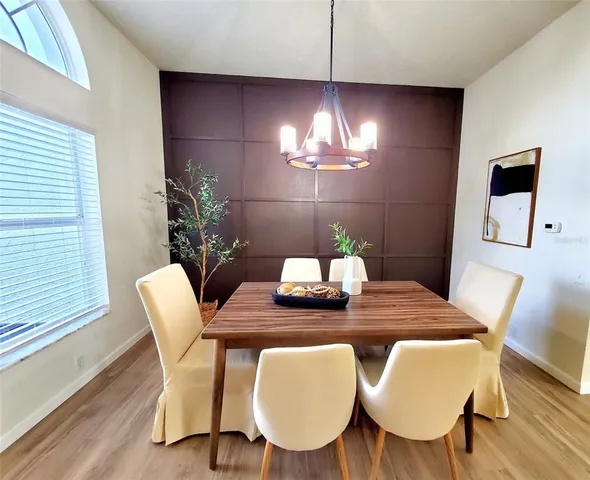 a view of a dining room with furniture a chandelier and wooden floor