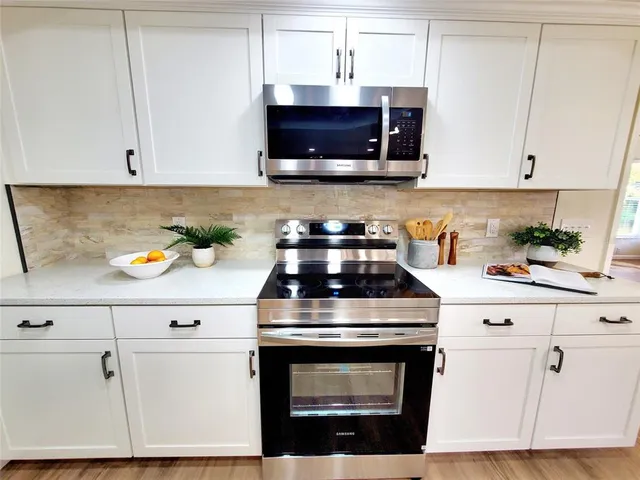 a kitchen with stainless steel appliances granite countertop a stove a microwave and cabinets