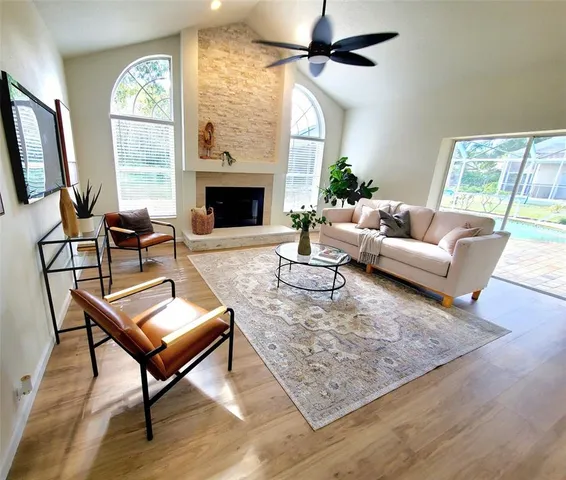 a living room with furniture a flat screen tv and a fireplace