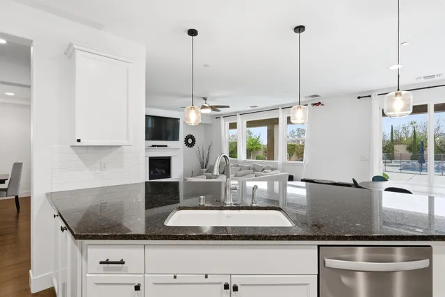 a kitchen with stainless steel appliances granite countertop a sink refrigerator and cabinets