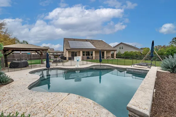a view of a swimming pool with a table and chairs under an umbrella