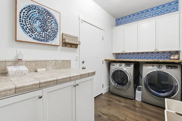 a bedroom with a bed a large window and wooden floor