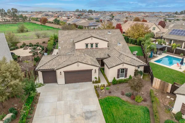 an aerial view of a house with swimming pool and outdoor seating