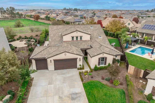 an aerial view of a house with swimming pool and outdoor seating