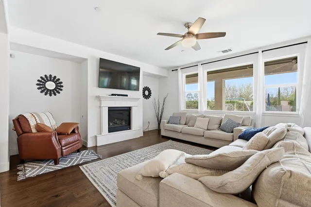 a living room with furniture a flat screen tv and a fireplace