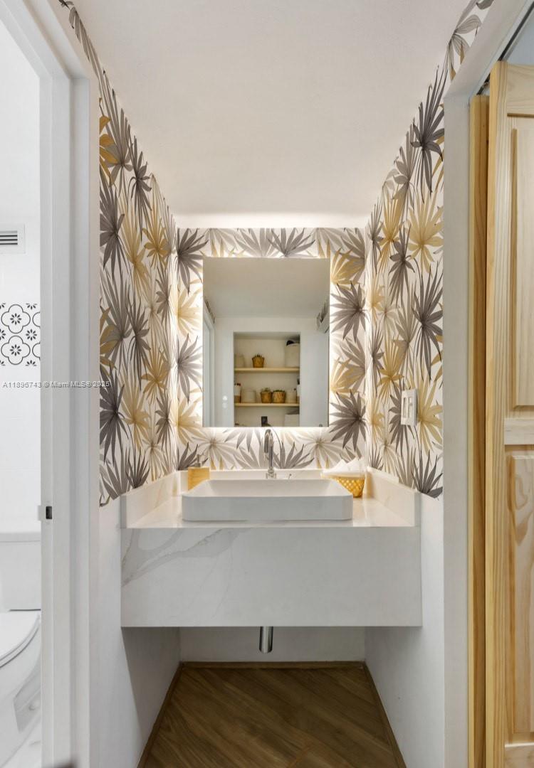 2899 Collins Avenue, Unit 1638 Miami Beach, FL 33140 - Photo 4 of 14 a bathroom with a sink and a mirror