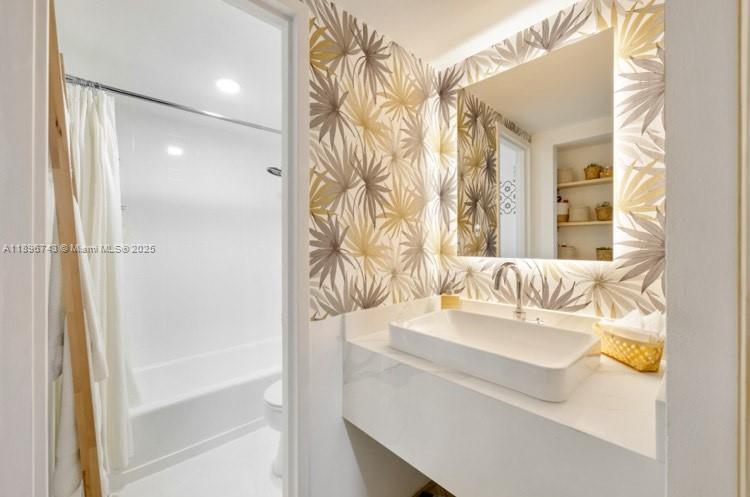 2899 Collins Avenue, Unit 1638 Miami Beach, FL 33140 - Photo 5 of 14 a bathroom with a sink and a mirror