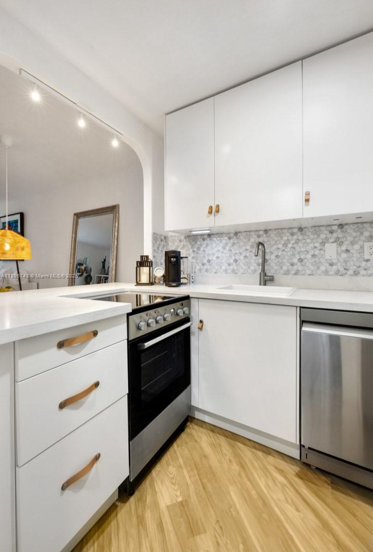 2899 Collins Avenue, Unit 1638 Miami Beach, FL 33140 - Photo 6 of 14 a kitchen with stainless steel appliances granite countertop a stove a sink and a microwave