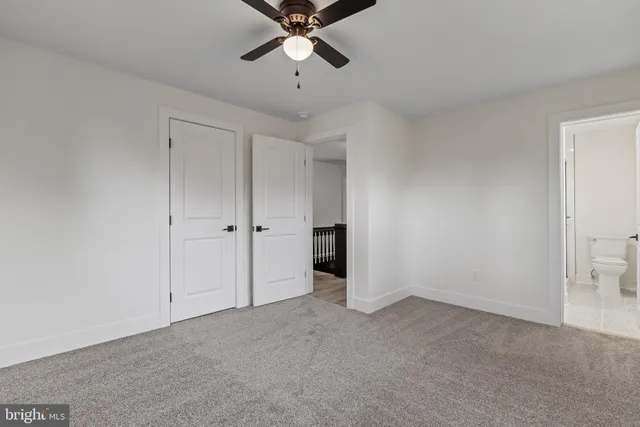 a view of an empty room and chandelier fan