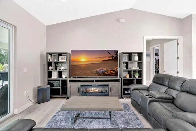 a dining room with wooden floor a chandelier a wooden table and chairs